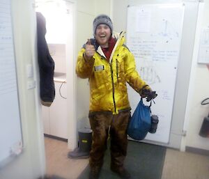 Aaron, one of the volunteers, in his wet weather clothing covered in mud