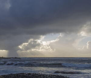 Crepuscular rays extending from the bottom of storm clouds west of Handspike Point