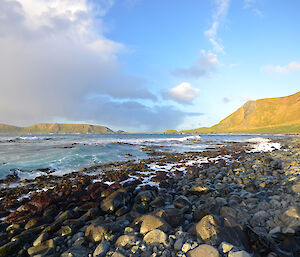 Northeast view along the rocky coastal beach with North Head in the distant left and Perseverance Bluff on the right