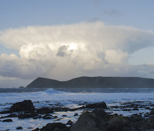 View across Hasselborough Bay at a well developed cumulonimbus cloud (thunderstorm cloud shaped like a mushroom) behind North Head. The rocky shore is in the foreground