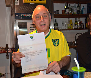 Chef holding out his birthday letter from the Norwich city football team to show