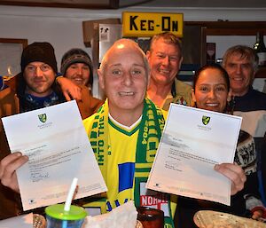 Chef sitting at the bar with two letters wishing him a happy Birthday from the Norwich City Football club, one from the Manager Mr Chris Hughton and one from the Captain Mr Grant Holt.All the Macquarie crew are standing around him.