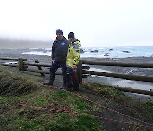 Chris and patty standing at the edge of the area of excavation, the area has been quarden off into a grid with pink string