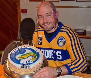 Craig with streamers on his head showing his cake