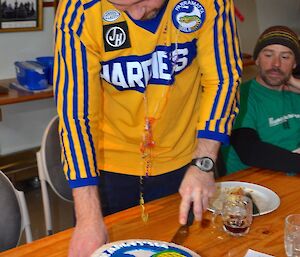 Craing cutting his cake and in the background Marty watches