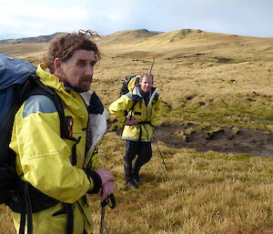 MIPEP Hunters Mike and Billy dressed in yellow AAD jackets with backpacks on, on top of the plateau, Macquarie Island