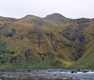 View from on of thew boats towards the rugged steep slopes of the coast near the base of Mt Jeffryes. Three waterfalls can be seen cascading down the slopes