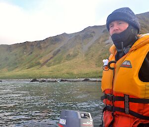 View from one of the boats, with Chris, our skipper, in the foreground, guiding our boat northward after dropping off Mark and Greg . The rugged slopes of the island are in the background