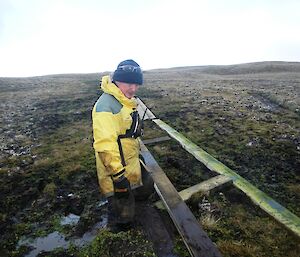 Chris, standing almost knee deep in mud and next to some unfinished boardwalk, pausing for a moment to work out the best way to get the job done