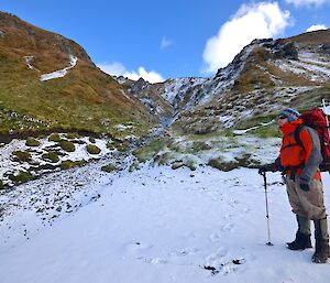 On the left of picture is Aaron standing on the snow covered slope at the base of Gadgets Gully. There are a few penguins on the left slope of the gully