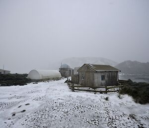 View of the station in bleak cloudy conditions. Snow is falling and the ground is covered in snow and ice