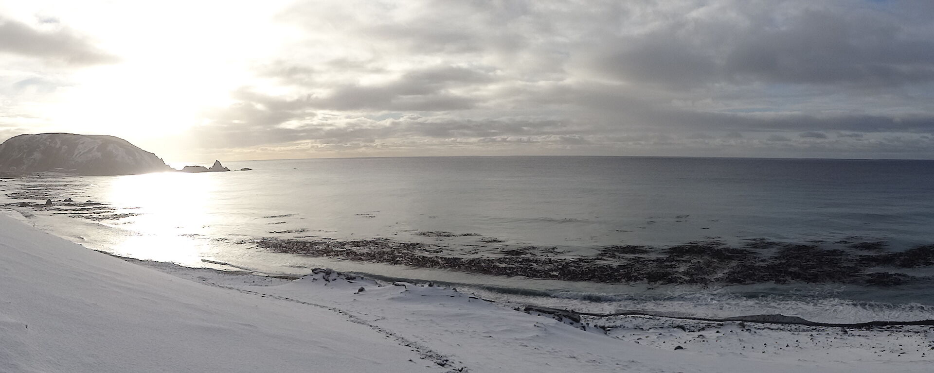 Ocean view with the hill covered in snow and North head in the distance