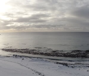 Ocean view with the hill covered in snow and North head in the distance