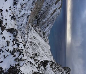 Looking down Gadgets creek covered in snow with the ocean in the distance and a stormy cloud over the water