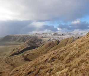 A photo of the mountain range with snow and blue sky with fluffy clouds