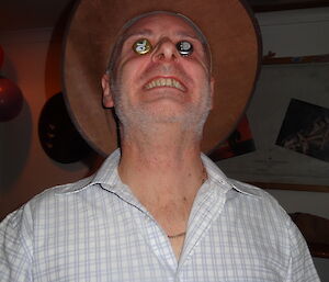 Tony wearing bottle top lids as eyes and his cow boy hat