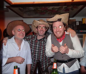 Greg, Aaron and tony wearing bottle top lids as eyes dressed up as cowboys wearing cowboy hats