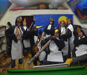 Macca group dressed as penguins playing instruments