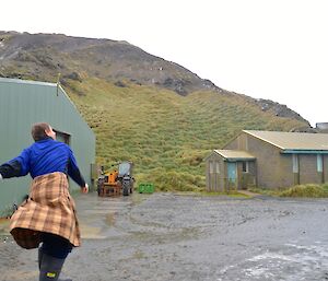 Tom, wearing a tartan kilt, standing on the half drum, having just hurled his haggis