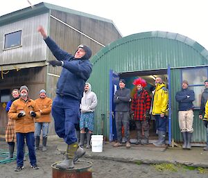 Tony (standing on the half drum), watched by the enthusiastic crowd, puts all his effort into hurling the haggis