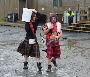Dean and Billie both dressed in a kilt and wearing blue make-up (Brave Heart) walking to the throwing area. Billie is playing the bag pipes