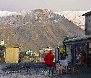 Nancye Williams and Angel Newport with their dogs standing in front of the workshops with the isthmus and snow covered hills in the background