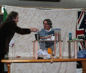 Aaron hands Bernard a bowl of yoghurt to finish breakfast