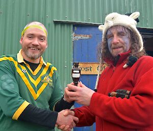 The Prize — New Zealand team captain Billy, hands the trophy to the Australian team captain Craig