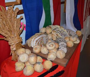 More beautiful food on display — bread rolls with display of a sheaf of grain in the back of the display