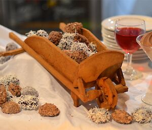 A beautiful display — a small wheel barrow (made of biscuit) filled with and surrounded by a variety of sweets and truffles.
