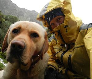 Karen, dressed in her yellow wet weather gear, and Finn shelter from a hail storm