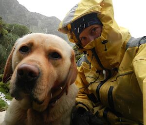 Karen, dressed in her yellow wet weather gear, and Finn shelter from a hail storm