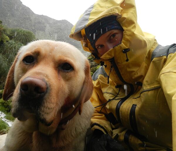 Karen, dressed in her yellow wet weather gear, and Finn shelter from a hail storm