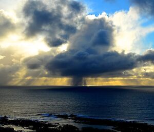 West coast squall — shows a large backlit cumulus cloud with a shower, squall coming from the base of the cloud