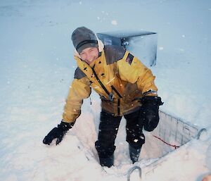 Ange standing in the hole she has dug in the snow in the cage pallet