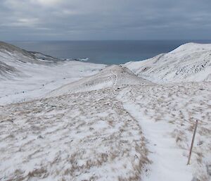Not so Sandy track to Sandy Bay. The countryside is extensively covered in snow, though the track can be seen heading towards the coast