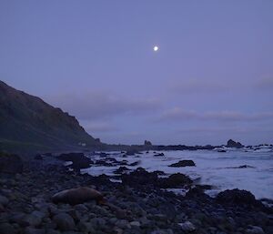 Looking towards Hurd Point, with the moon high up. You can see Hurd Point hut in the distance at the base of the steep slope