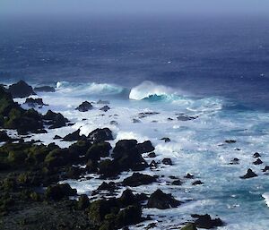 Big surf can be seen breaking on a rocky coastline near Hurd Point
