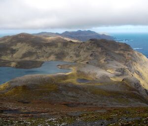 View south from Mount Waite — shows many hills and lakes with glimpses of the ocean on both sides of the picture