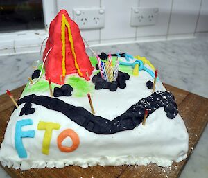 Marty’s birthday cake, beautifully decorated, complete with pyramid tent, tent pegs, guy ropes, a walking path with track markers and the letters FTO on the side of the cake