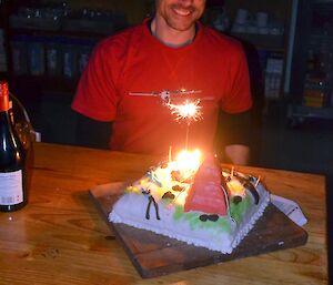 Marty with his birthday cake. It has a single burning sparkler and several lit candles