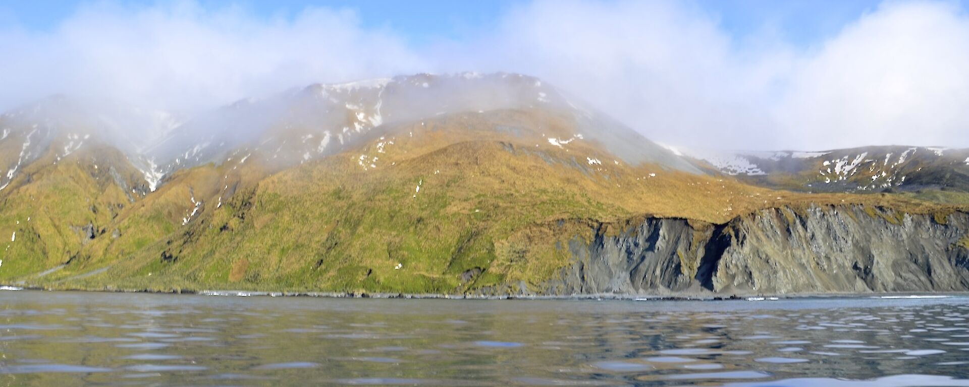 Taken from one of the boats looking across the ‘glassy’ water at the escarpment just south of the Nuggets. There is patches of snow on the slopes and the tops are covered in misty cloud