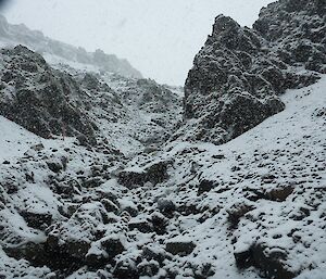 Looking up the jagged rocks on the creek jump up from Hurd Point. There is a lot of snow cover and it is snowing quite heavily