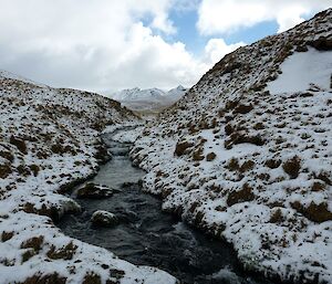 Looking west from the Jessie Niccol track up Jessie Niccol Creek. The landscape is covered in snow and Mt Blake can be seen in the distant background