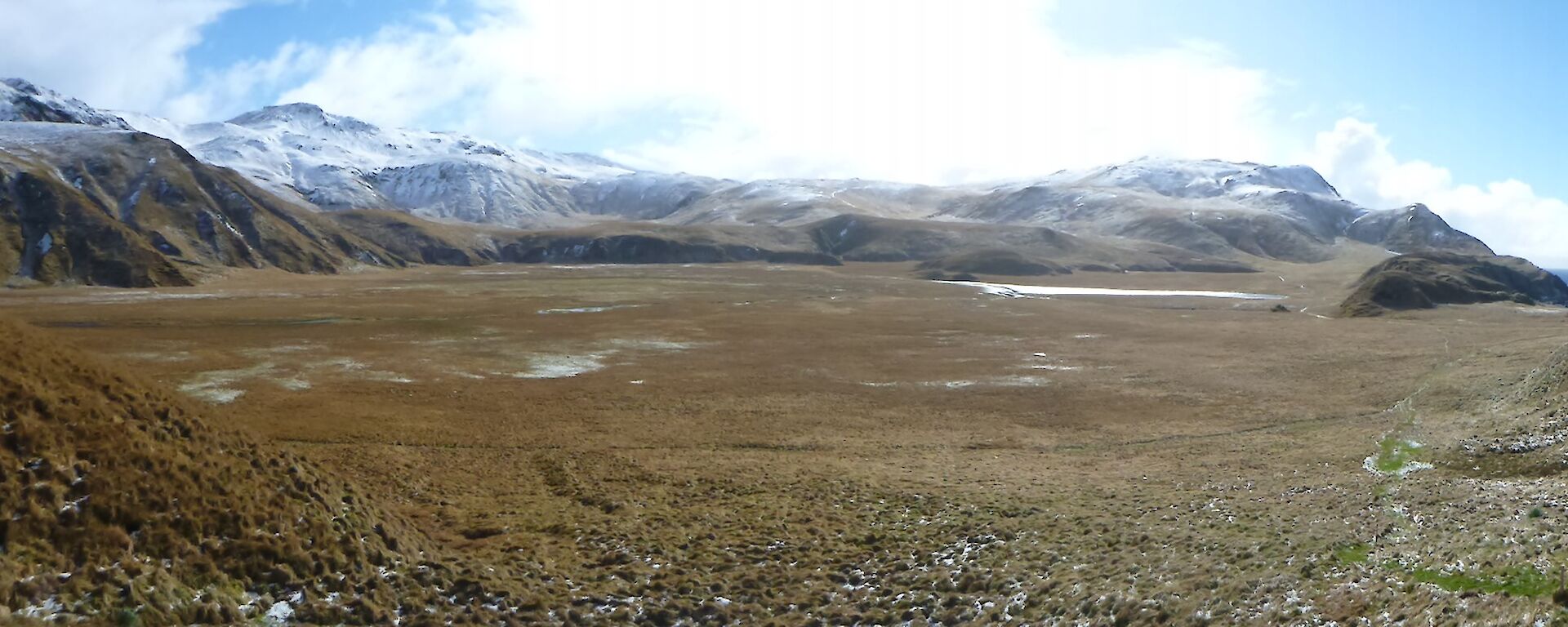 Looking north — panorama of the hinterland at Green Gorge, showing a broad flat valley with snow covered peaks in the distance north of the valley