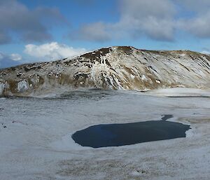 Looking west from the Overland track — Midas tarn in the middle and Red River valley on the left with unknown peaks beyond the tarn. The landscape is covered in snow