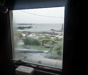 Green Gorge channel — Looking through a hut window onto the beach at green gorge with a light cover of snow and an ele seal harem on the water’s edge