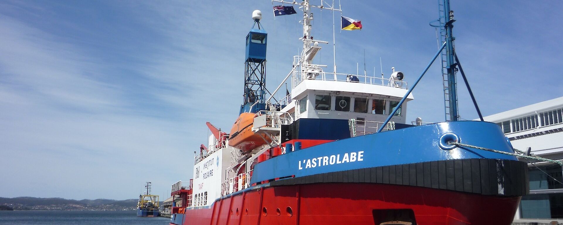 L'Astrolabe, brightly painted red, white and blue, tied up at the wharf just prior to departure form Hobart