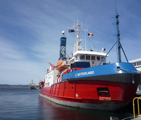 L'Astrolabe, brightly painted red, white and blue, tied up at the wharf just prior to departure form Hobart