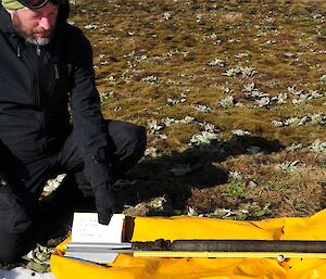 Mark Gasson crouching next to the first Livingston piston core drive of about 84cm length